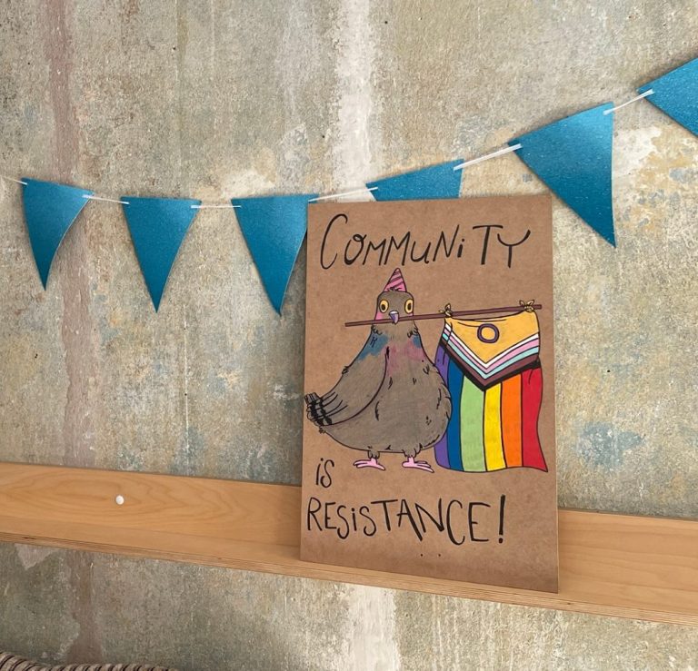 Eine bunte Zeichnung eines Vogels mit einem Regenbogenbanner und dem Text „Community ist Resistance!“